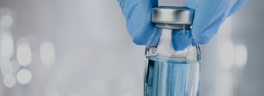 Gloved hand holding a vial